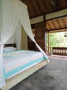 a bedroom with a bed with a mosquito net at duegoal farmhouse in Jatiluwih
