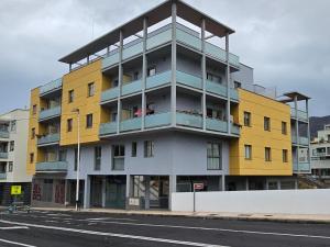 ein gelbes und weißes Gebäude an der Straßenseite in der Unterkunft Vivienda vacacional Rous in Los Llanos de Aridane