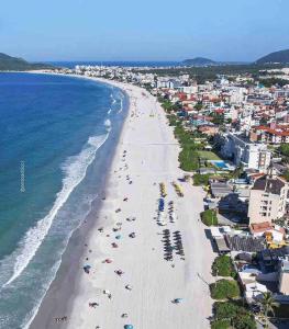 - une vue aérienne sur une plage avec des parasols et l'océan dans l'établissement Lindo apartamento, a 300 m da Praia dos Ingleses!, à Florianópolis