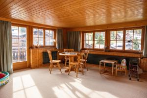 a room with a table and chairs and windows at Chalet Egghus Klosters in Klosters