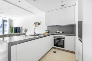 a white kitchen with a sink and a stove at Premium Downtown apartment 2BD, 5 MIN DUBAI MALL in Dubai