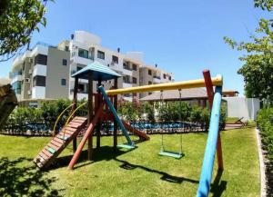 un parc avec une aire de jeux avec un toboggan et des balançoires dans l'établissement Lindo apartamento, a 300 m da Praia dos Ingleses!, à Florianópolis