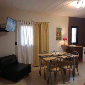 a living room with a table and chairs and a television at Chalet Arena Malva in San Bernardo +24 photos