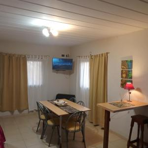 a living room with a table and chairs and a tv at Chalet Arena Malva in San Bernardo