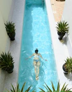una mujer nadando en una piscina en una piscina en Riad Kheirredine en Marrakech