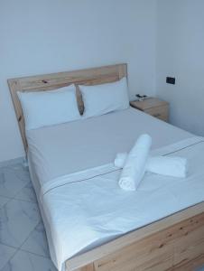 łóżko z białą pościelą i poduszkami w obiekcie Appartement Hajar w mieście Oualidia