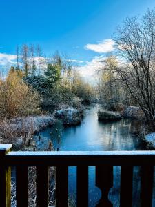 una valla con vistas al río en invierno en Secluded Rustic Cabin - A Digital Detox Paradise. en York