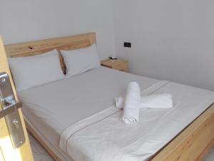 een wit bed met 2 opgerolde handdoeken bij Appartement Hajar in Oualidia