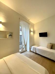 una camera con due letti e una grande finestra di Blanco B&B - Group a Trani