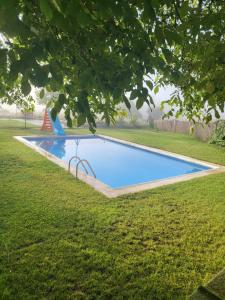 una piscina en un patio con césped en Estancia Vacacional Las Nogueras en Cuenca