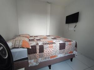 a bedroom with a bed with a quilt on it at KitNet Confort Garanhuns (101) in Garanhuns