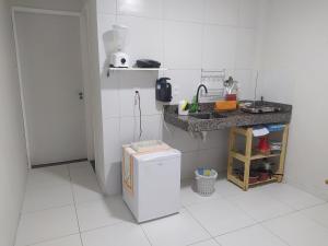 a small white kitchen with a refrigerator and a counter at KitNet Confort Garanhuns (101) in Garanhuns