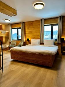 a bedroom with a large bed in a room with windows at Alpen Lodge Riezlern in Riezlern