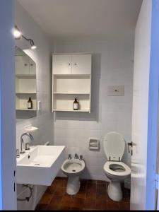 a white bathroom with a sink and a toilet at Deptos Sol y Mar in Necochea