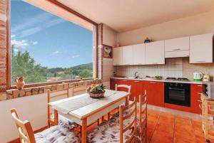 イトリにあるCASA DEL CAVALIERE con terrazza e piscinaのキッチン(テーブル、椅子付)、大きな窓が備わります。