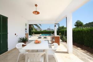 a white table and chairs on a patio with a pool at Villa La Vinya Can Oliver - Oliver in Pollença