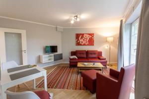 a living room with a red couch and a table at Ferienwohnung Bibi Bocksberg Hahnenklee in Goslar