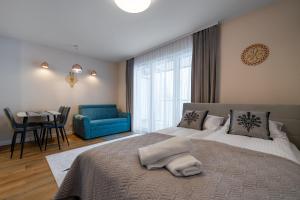 Un dormitorio con una cama grande y una silla azul. en RentPlanet - Apartamenty Zakopiańskie II, en Zakopane 143 fotos más