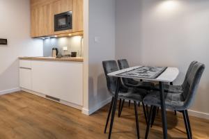Una cocina con una mesa y sillas en una habitación. en RentPlanet - Apartamenty Zakopiańskie II, en Zakopane