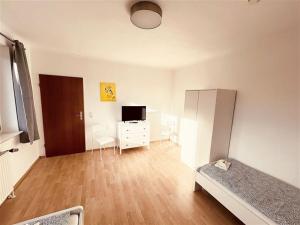 ein Schlafzimmer mit einem Bett, einer Kommode und einem TV in der Unterkunft Fully eqiupped apartment in Winsen (Luhe) in Winsen