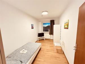Kleines Zimmer mit einem Bett und einem Kühlschrank. in der Unterkunft Fully eqiupped apartment in Winsen (Luhe) in Winsen