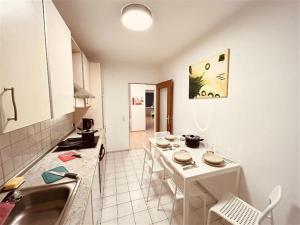 eine Küche mit einem Tisch und einem weißen Tisch und Stühlen in der Unterkunft Fully eqiupped apartment in Winsen (Luhe) in Winsen