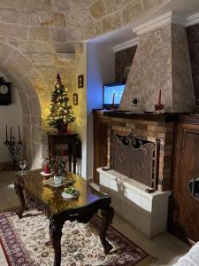 a living room with a fireplace and a christmas tree at Trullo Di Tagaro in Locorotondo
