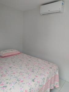 a bedroom with a bed with a floral bedspread at Kitnet ótima localização em Garanhuns (103) in Garanhuns