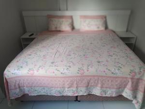 1 dormitorio con cama rosa y colcha rosa en Kitnet ótima localização em Garanhuns (103), en Garanhuns