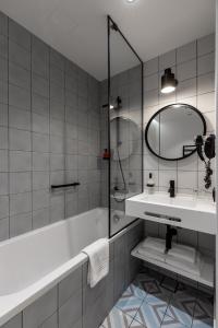a bathroom with a tub and a sink and a mirror at Konventa Sēta Hotel Keystone Collection in Rīga
