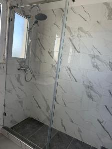 a bathroom with a shower with white marble tiles at Duplex Marina de Vilamoura in Vilamoura