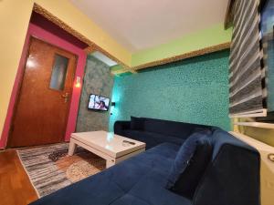 ein Wohnzimmer mit einem blauen Sofa und einem Tisch in der Unterkunft Sarı Köşk Butik Otel in Bursa