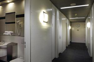 a hallway with a bathroom with a toilet and a sink at Mercure Hotel Schiphol Terminal in Schiphol