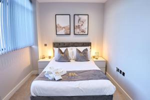 a bedroom with a large bed with two pillows at Pluxa Arctic - College Road Retreat with Full Apt Full Access in Harrow on the Hill