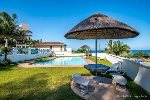 a patio with a table and an umbrella at Tahiti Dreaming in Umdloti