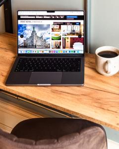 un ordenador portátil sentado en un escritorio con una taza de café en First Hotel Christian IV, en Kristianstad