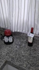 een fles wijn bovenop een aanrecht bij Apartamento Juvevê. in Curitiba