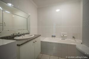 a bathroom with a sink and a tub and a mirror at 33 Waterfront with Inverter in Umdloti +17 photos