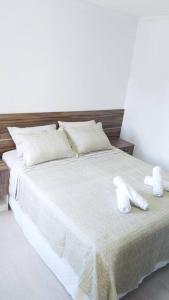 Una cama blanca con dos toallas blancas. en Apartamento Juvevê., en Curitiba