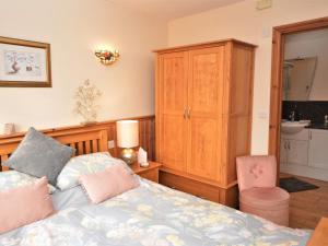 Schlafzimmer mit einem Bett und einem Holzschrank in der Unterkunft 1 Bed in Tavistock COLCH in Gunnislake