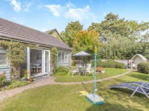 a garden with a table and an umbrella at 2 Bed in Barnstaple OLDMA in Landkey