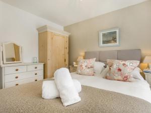 a bedroom with a bed and a dresser with a mirror at 2 Bed in Barnstaple OLDMA in Landkey