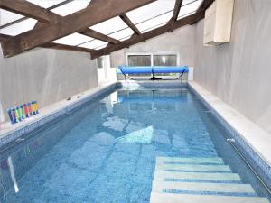 a large swimming pool with blue water in a building at 3 Bed in Sidmouth HARRI in Talaton