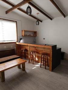 um quarto com um bar com bancos e uma mesa em Punto clave em Pudeto