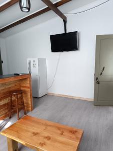 Habitación con mesa, TV y nevera. en Punto clave, en Pudeto