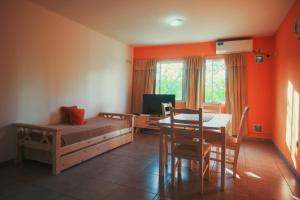 1 dormitorio con cama, mesa y comedor en Céntrico Departamento Tangerine San Rafael en San Rafael