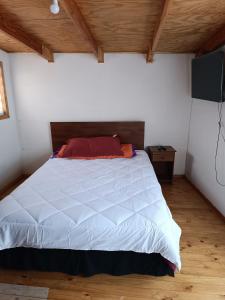 1 dormitorio con cama blanca y techo de madera en Punto clave, en Pudeto