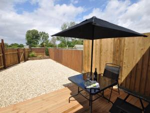 un ombrello nero seduto su un patio con tavolo di 1 Bed in Burnham-on-Sea ALHSL a Highbridge