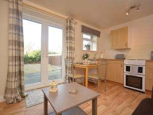 a living room with a table and a kitchen with a window at 1 Bed in Burnham-on-Sea ALHSL in Highbridge