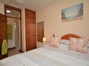 a bedroom with a large bed with pink pillows at 1 Bed in Bude THENO in Bude